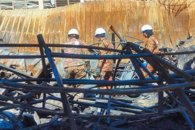 Anggota unit forensik Jabatan Bomba dan Penyelamat sedang melakukan kerja penyiasatan punca kebakaran di lokasi kejadian pada Isnin.