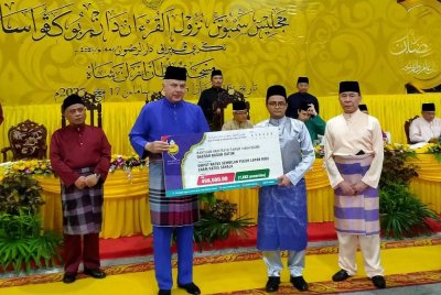 Sultan Nazrin (dua dari kiri) berkenan menyampaikan bantuan Hari Raya Aidilfitri MAIPk sempena Majlis Sambutan Nuzul Al-Quran dan Berbuka Puasa Peringkat Negeri Perak di pekarangan Masjid Sultan Azlan Shah pada Isnin.