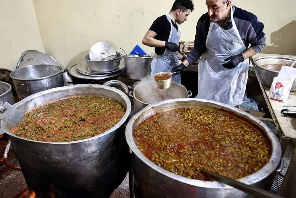 Sukarelawan Projek Amal Ramadan menyediakan juadah berbuka untuk diagihkan kepada keluarga miskin di Ramallah.