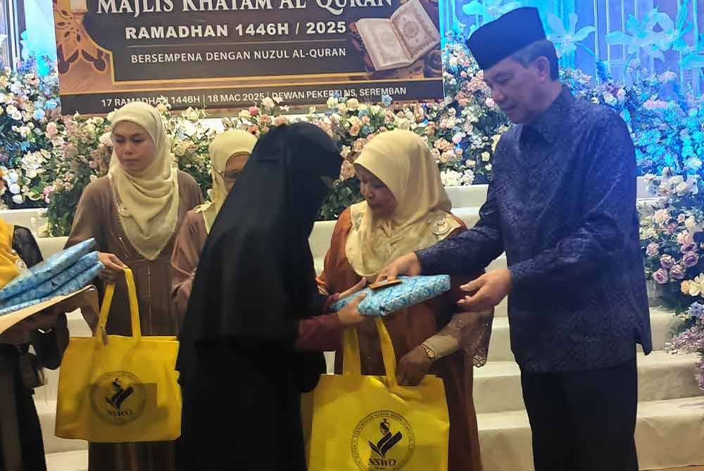 Mohamad menyampaikan sumbangan kepada penerima pada Majlis Khatam al-Quran diadakan di Dewan Pekerti hari ini.