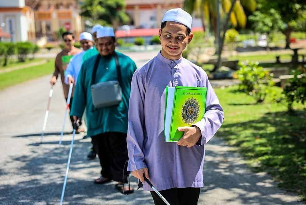 Muhammad Rifaa Haiduri, 22, bersama beberapa orang rakannya bergerak secara berkumpulan dengan membawa al-Quran Braille mashaf Malaysia untuk dibaca sempena Nuzul Quran di pekarangan Masjid Darul Quran Jakim pada Selasa. Foto Bernama