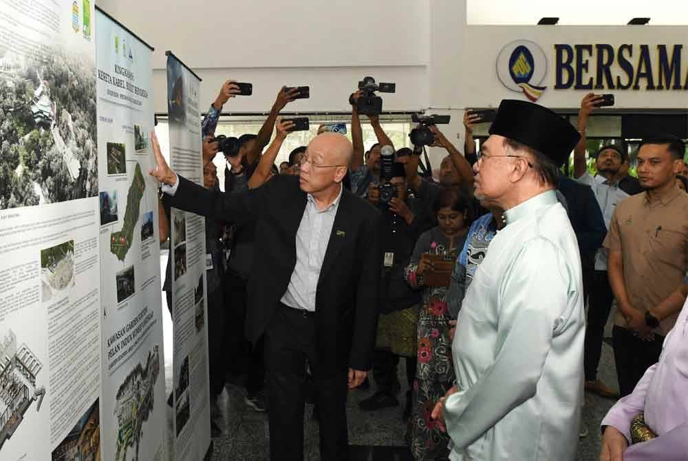 Pengurus Besar Perbadanan Bukit Bendera, Datuk Cheok Lay Leng (kiri) menerangkan pembangunan Bukit Bendera pada Anwar semasa hadir Mesyuarat Khas Pembangunan Negeri Pulau Pinang di PDC pada Selasa. Foto Bernama