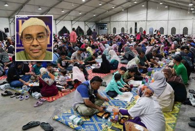 Pengunjung menikmati juadah berbuka puasa di dalam khemah yang disediakan ketika keadaan cuaca tidak mengizinkan. Gambar kecil: Md Nazri