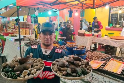 Noor Erwan menunjukkan pelbagai jenis kerang dan siput yang disediakan untuk pelanggan.