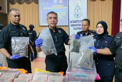 Mat Zaini (dua dari kiri) menunjukkan bunga ganja dirampas.