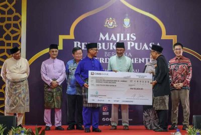 Anwar (lima, kiri) menyaksikan Ketua Pegawai Eksekutif Perbadanan Pembangunan Pulau Pinang (PDC), Datuk Aziz Bakar (empat, kiri) menyampaikan replika cek kepada Pengerusi Masjid Abu Ubaidah Ibni Al-Jarrah, Abd Nasir Salleh (dua, kanan) pada Majlis Berbuka Puasa bersama Perdana Menteri di Bandar Tasek Mutiara pada Selasa. Foto Bernama