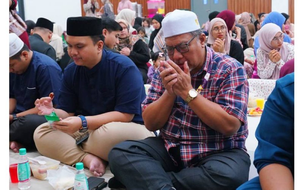 Salah seorang peserta mengaminkan doa berbuka puasa.