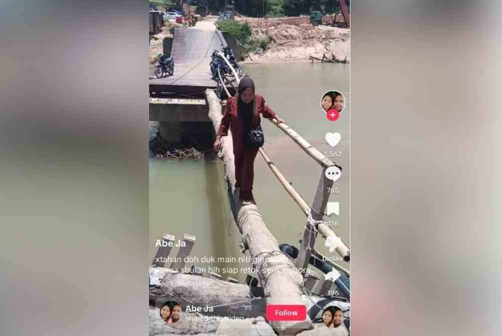 Tangkap layar video tular wanita mengandung melintasi titi batang pokok durian di Kampung Temalir Lama.