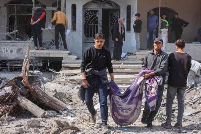 Rakyat Palestin mengusung mayat yang dikeluarkan dari runtuhan rumah keluarga Qrayqea, yang musnah dalam serangan Israel pada waktu subuh di daerah Shujaiya, di bandar Gaza Timur. Foto AFP