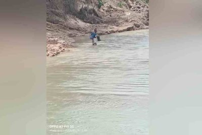 Yusof melintasi sungai untuk pulang ke rumahnya di Kampung Temalir lama. Foto Pembca Sinar Harian