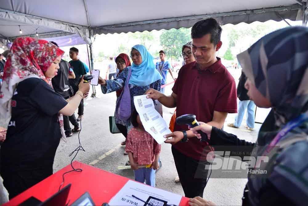 Pengunjung Iftar Ala Madinah perlu mengemukakan kod QR pendaftaran sebelum mengambil tempat duduk dan berbuka puasa. FOTO: ASRIL ASWANDI SHUKOR