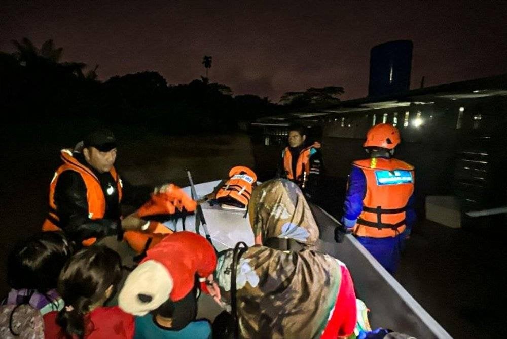 Anggota keselamatan membantu penduduk berpindah.