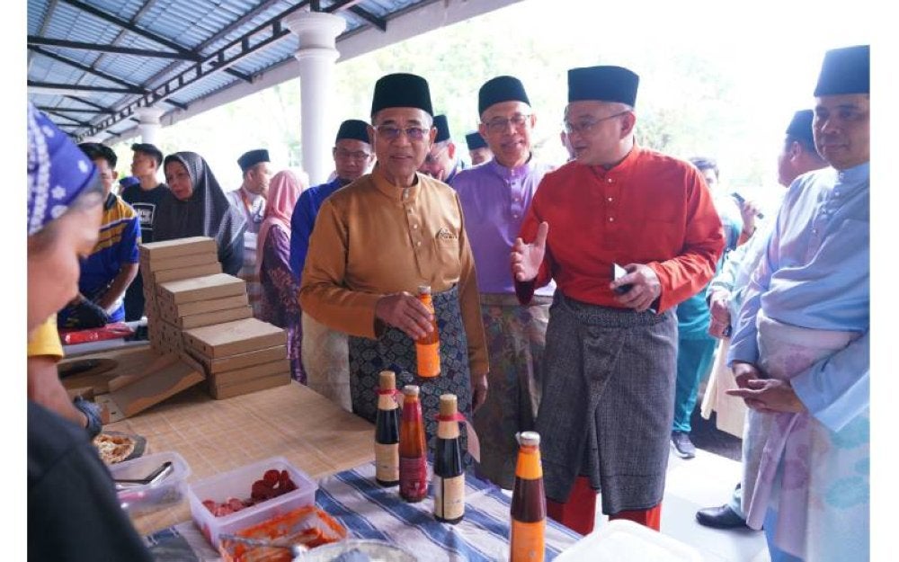 Mohd Jazri (dua, kanan) mengiringi Pengerusi UniKL, Datuk Seri Sh Mohmed Puzi Sh Ali melawat dapur operasi bagi menghasilkan pizza.