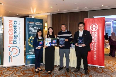 Ketua Pegawai Eksekutif OMSMC, Lee Soon Teck (dua, kanan) dan Pengarah Operasi Global Precision Diagnostics, Maria Phang Sue Chieng (dua, kiri) menunjukkan maklumat mengenai perkhidmatan PRECISE Pharmagenomics (PGx).