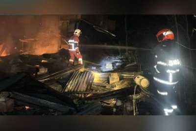 Anggota bomba memadamkan kebakaran rumah di Kampung Kuala Semantan, Cheroh, Raub pada awal pagi Khamis.