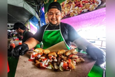 Shazzuan menunjukkan roti john udang selambak yang dijualnya.