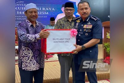 Mohd Nassuruddin (kiri) dan Mohamed Fadzli (tengah) menyampaikan sumbangan kuih raya kepada Ketua Polis Kelantan, Datuk Mohd Yusoff Mamat pada Majlis Penyerahan Sumbangan Kuih Raya Aidilfitri kepada Pasukan Keselamatan Negeri Kelantan di Kompleks Kota Darulnaim, Kota Bharu pada Khamis.