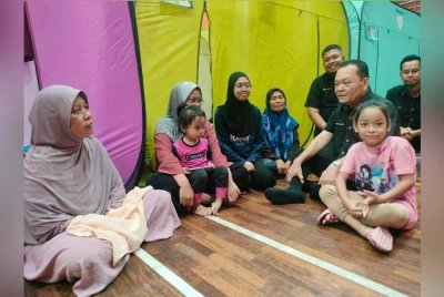 Abd Rashid (dua dari kiri) bertanya khabar kepada penduduk yang dipindahkan ke PPS Dewan MBIP, Skudai.