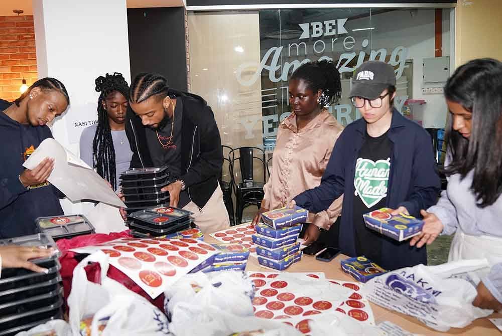 Pelajar Kolej Babson membantu sebagai sukarelawan dalam membungkus makanan yang disediakan untuk diagihkan kepada pengunjung Iftar Ala Madinah@Karangkraf pada Rabu.