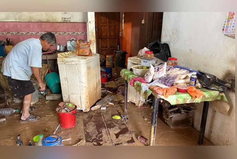 Mangsa banjir terpaksa membersihkan ruangan dalam rumah yang dinaiki air selepas banjir surut.