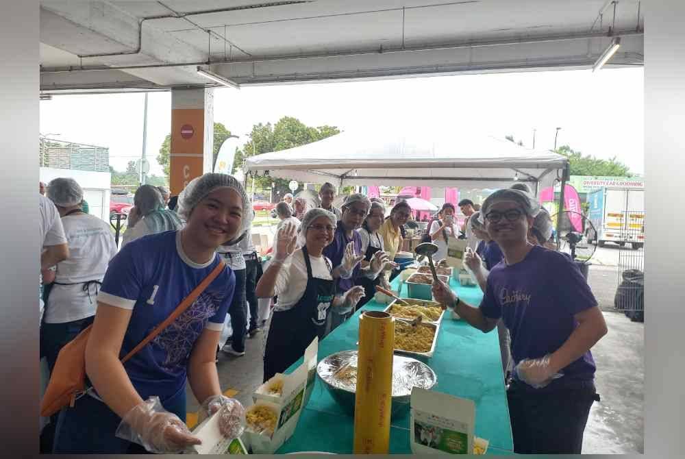 Azliza (dua dari kiri) bersama sukarelawan menyediakan juadah berbuka puasa kepada golongan memerlukan di Lotus's Kajang.