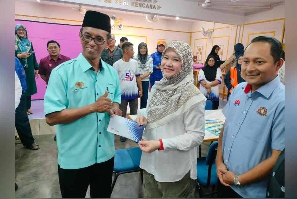 
Fadhlina (dua kanan) menyampaikan sumbangan di PPS SK Seri Kencana, Simpang Renggam, Kluang pada Jumaat.
