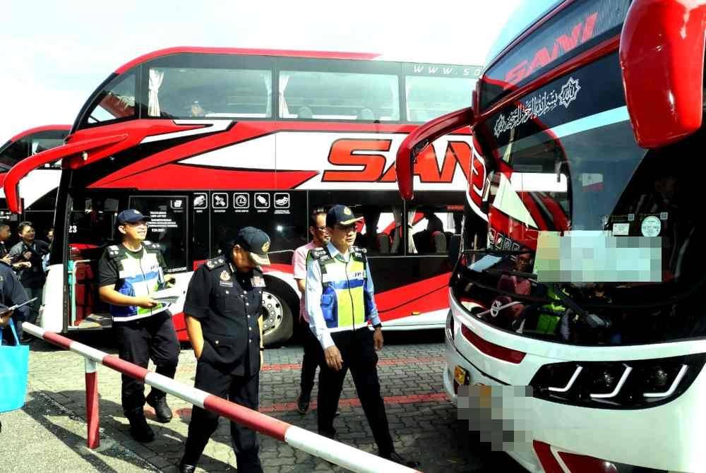 Azrin (kanan) meninjau pemeriksaan bas di Depoh Sani Express di Klang pada Jumaat.