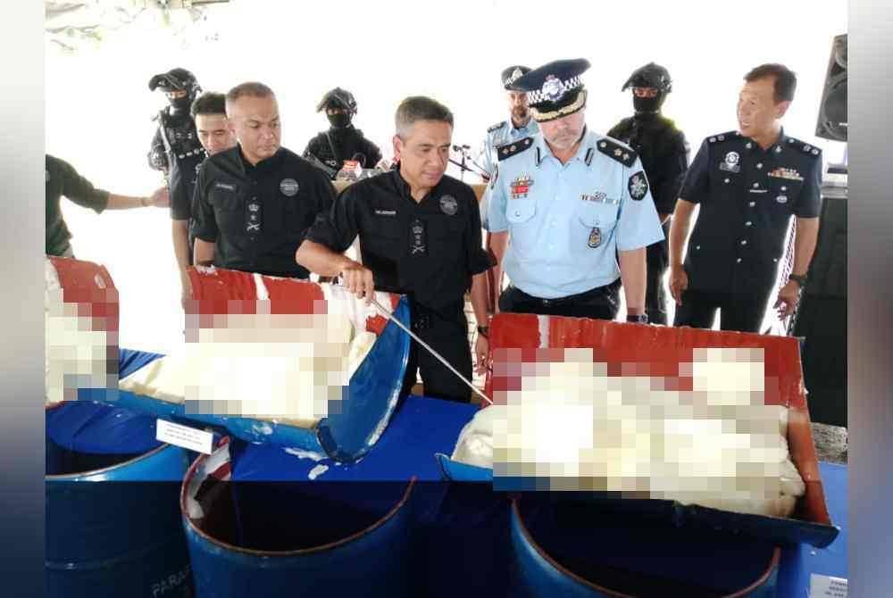 Mat Zani (tiga dari kiri) menunjukkan antara lilin yang mengandungi dadah dirampas dalam serbuan pada 25 Januari lalu.