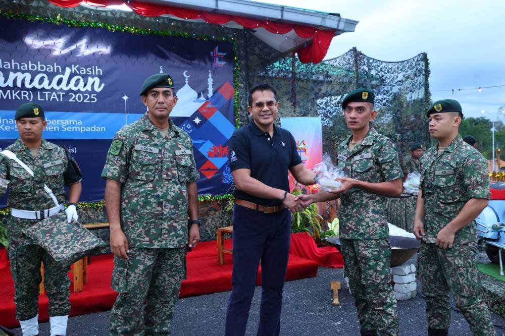 Ketua Jabatan Hartanah LTAT, Zairuddy Zainal (tiga dari kiri) bersama Pegawai Pemerintah Kem, Leftenan Kolonel Mohd Ezrin Daud (kiri), menyampaikan bubur lambuk kepada anggota 5 Rejimen Sempadan, Kem Bukit Kayu Hitam, Kedah.