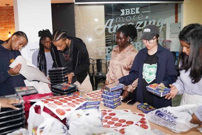 Pelajar Kolej Babson membantu sebagai sukarelawan dalam membungkus makanan yang disediakan untuk diagihkan kepada pengunjung Iftar Ala Madinah@Karangkraf pada Rabu.