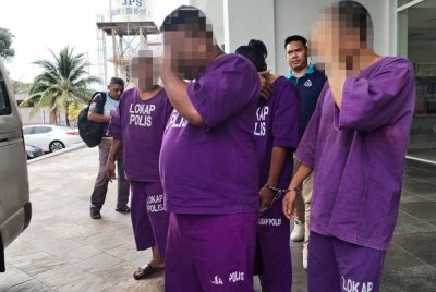 Suspek (dua dari kanan) ketika dibawa ke Mahkamah Sesyen Besut bagi proses tahanan reman.