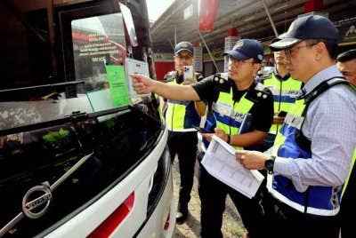 Azrin (kanan) meninjau pemeriksaan bas di Depoh Sani Express di Klang pada Jumaat.