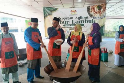 Dua dari kiri: Mohd Jazri, Isham, Noor Laili dan Lailah melakukan gimik mengacau bubur lambuk di pekarangan Dewan Serbaguna Wisma Tani, KPKM pada Jumaat.
