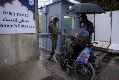 Seorang lelaki Palestin menjalani pemeriksaan kad pengenalan untuk melepasi pusat pemeriksaan Israel di Bethlehem, Tebing Barat, ketika jemaah menuju ke pekarangan Masjid Al-Aqsa di Kota Lama Baitulmaqdis bagi menunaikan solat Jumaat. Foto AFP