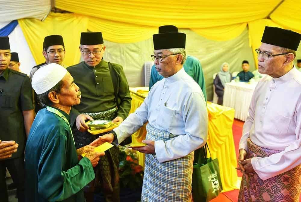 Al-Sultan Abdullah (tengah) menyampaikan sumbangan untuk asnaf terlibat sambil diperhatikan oleh Wan Rosdy (kanan) sempena majlis perasmian MTAR di Tanjung Gahai,Lipis pada Jumaat.
Foto ihsan Pahang Media