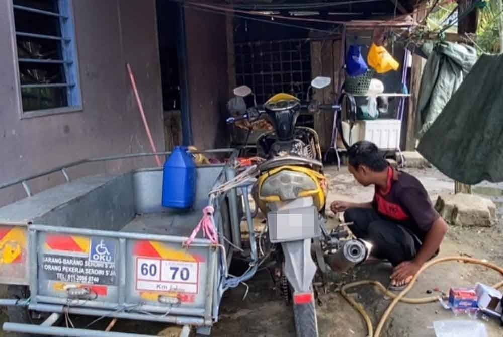 Nik Khairulzaman memeriksa motosikal yang kian uzur serta bakulnya hampir patah.
