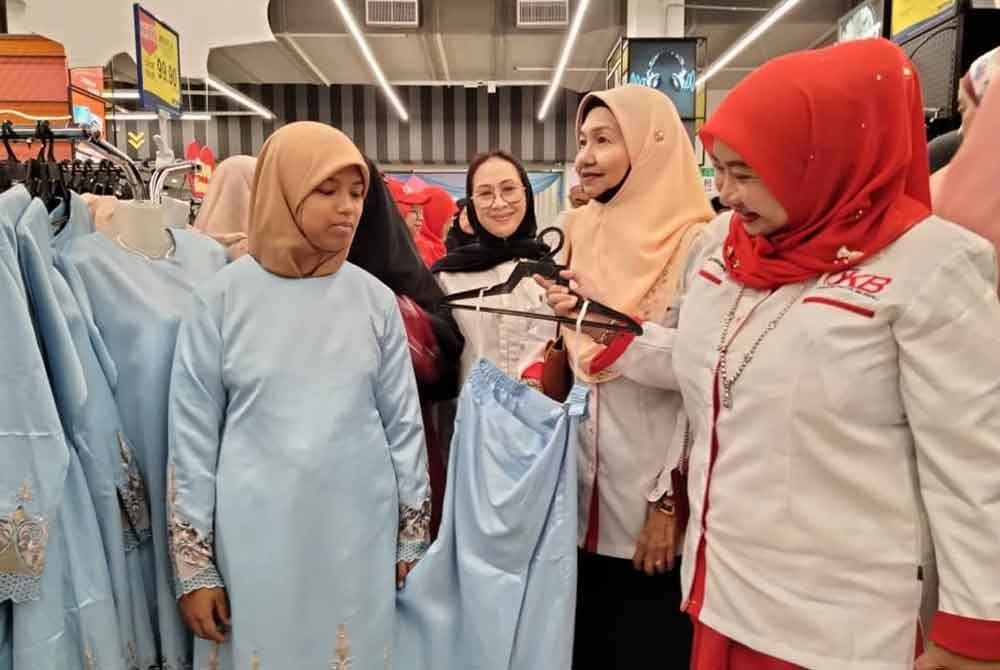 Ahli POKB turut membantu memilih pakaian anak yatim.