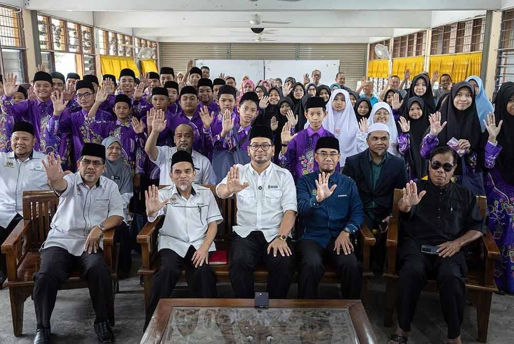 Dr Zulkifli Hasan (tengah) bergambar bersama para pelajar ketika hadir pada Program Ihsan MADANI di Sekolah Agama Bantuan Kerajaan Maahad Al-Ummah. Foto Bernama