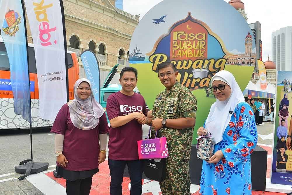 Syamil menyerahkan cenderamata kepada Mohd Nizam.