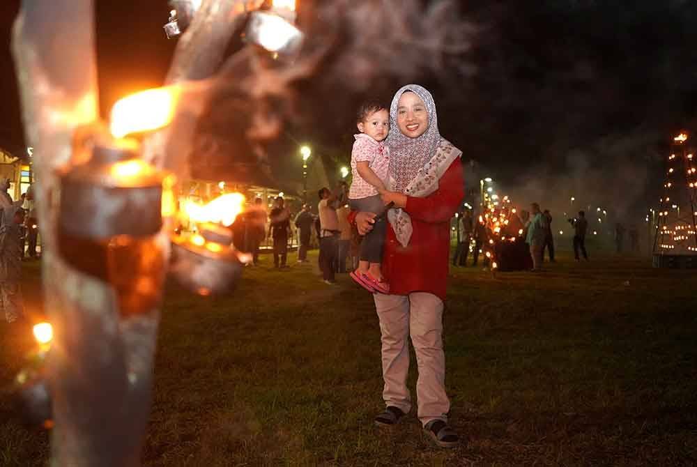 Orang ramai tidak melepaskan peluang membawa anak-anak menyaksikan kemeriahan pelita raya sempena program Peliter@Perasing di R&R Perasing pada malam Jumaat.