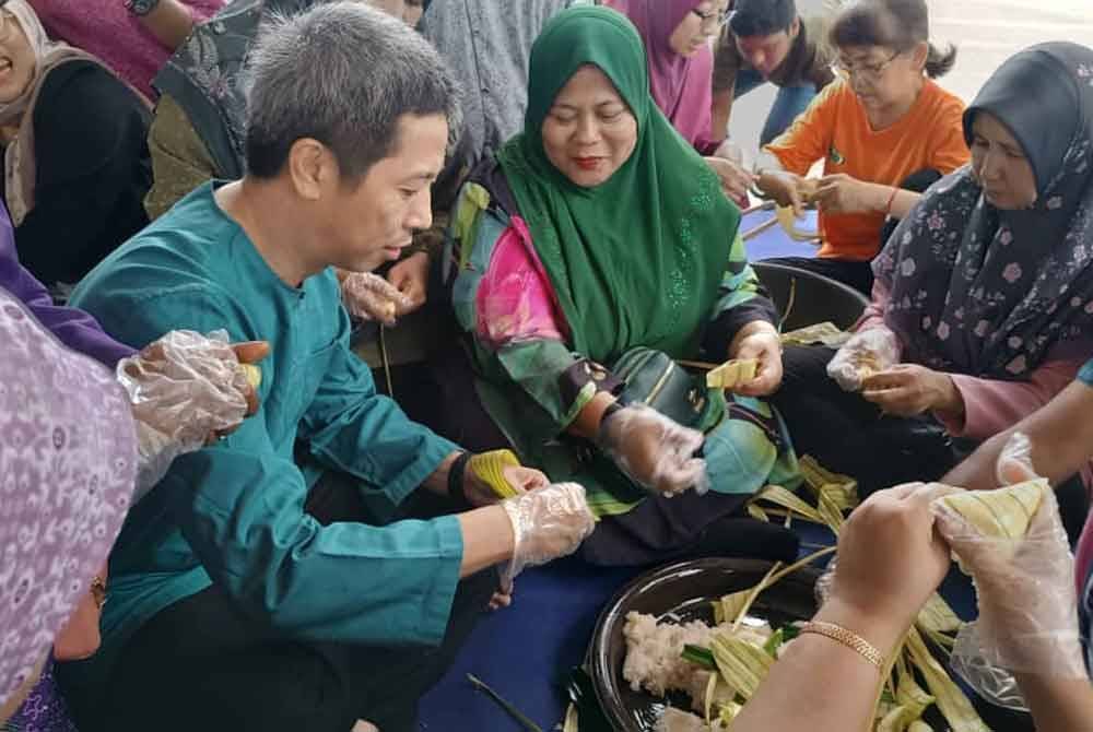 Hsiao Leung (kiri) turut menunjukkan kebolehannya menganyam ketupat