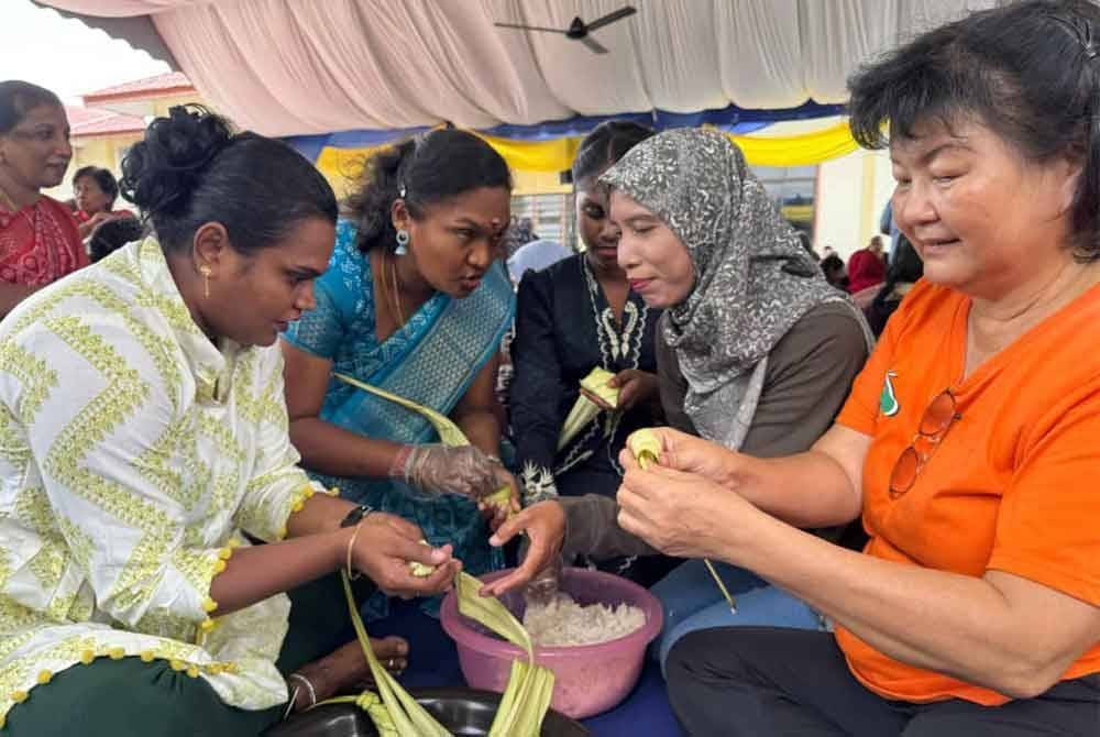 Pelbagai kaum mengambil bahagian dalam acara rewang ketupat yang diadakan pada Sabtu.