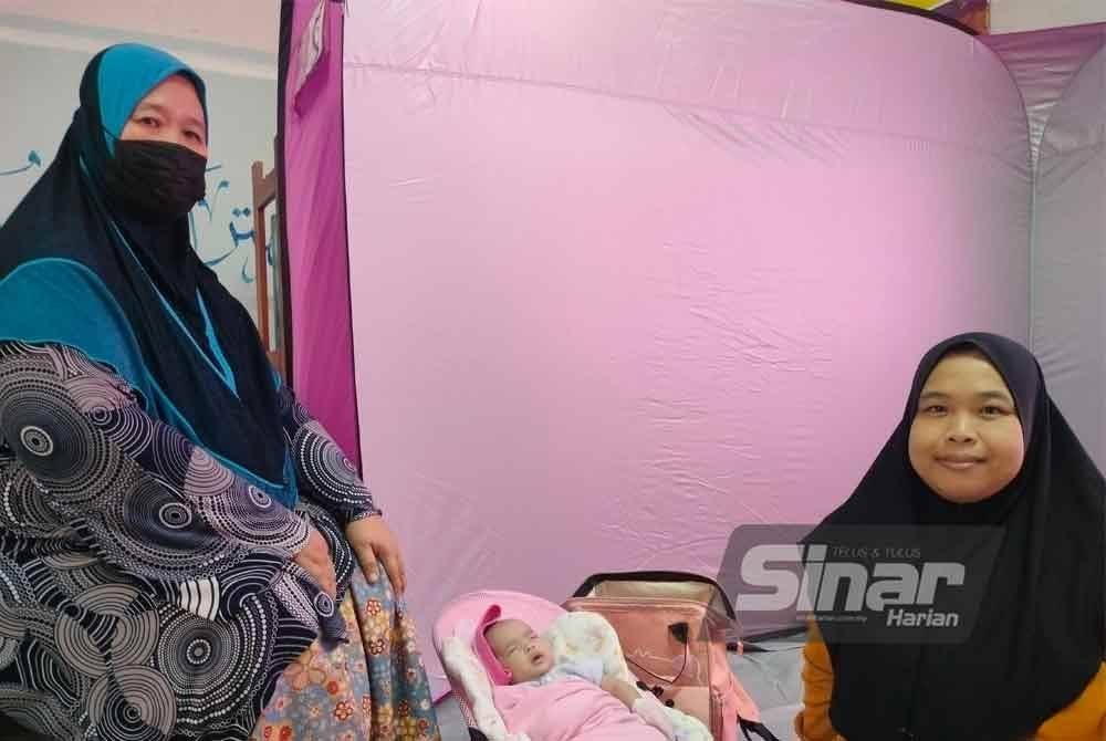 Siti Amyra (kanan) kini berpantang di PPS Sekolah Agama Kayu Pasong selepas rumahnya dinaiki air sejak Rabu.