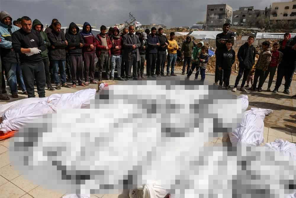 Rakyat Palestin menunaikan solat jenazah mangsa serangan rejim Zionis di hadapan Hospital Indonesia, Beit Lahia. - Foto: Agensi