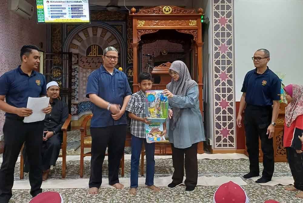 Ruhaidi (berdiri, dua dari kiri) menyaksikan penyampaian hadiah kepada pemenang pertandingan mewarna. Foto KDN