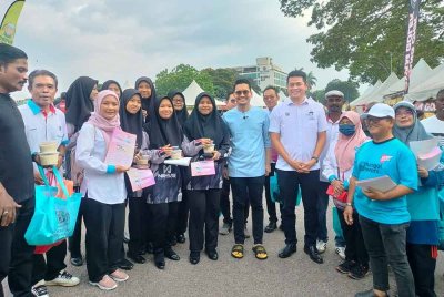 Mohammed Taufiq (tengah) bergambar bersama pengunjung Bazar Ramadan Taman Ria pada Jumaat.