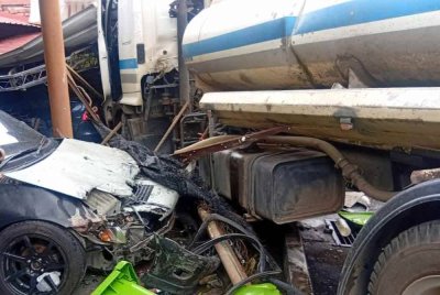 Keadaan lori tangki air milik PAIP yang terbabas merempuh rumah dan kereta di Taman Kenanga, Raub pada Sabtu. Foto JBPM Pahang