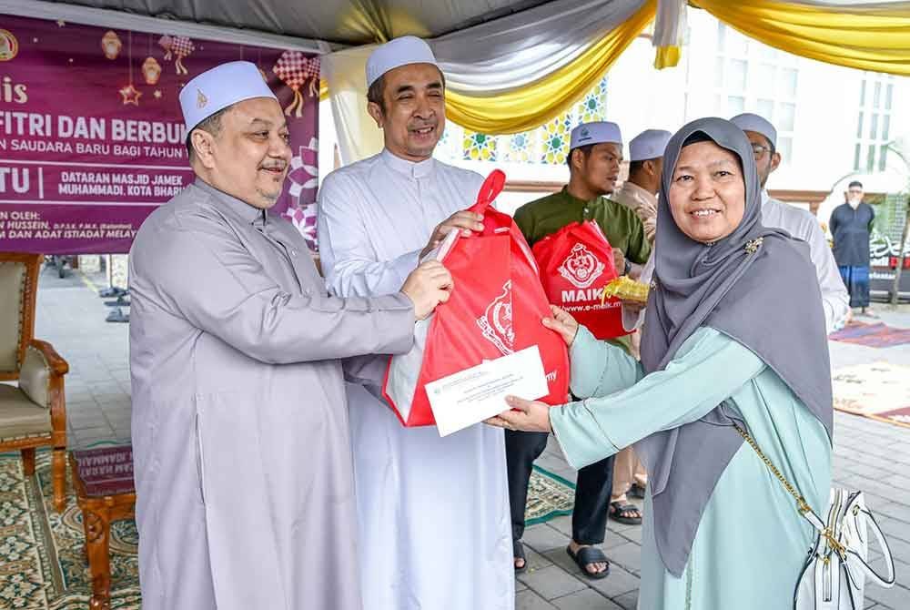 Hasnan (kiri) menyampaikan sumbangan kepada mualaf.