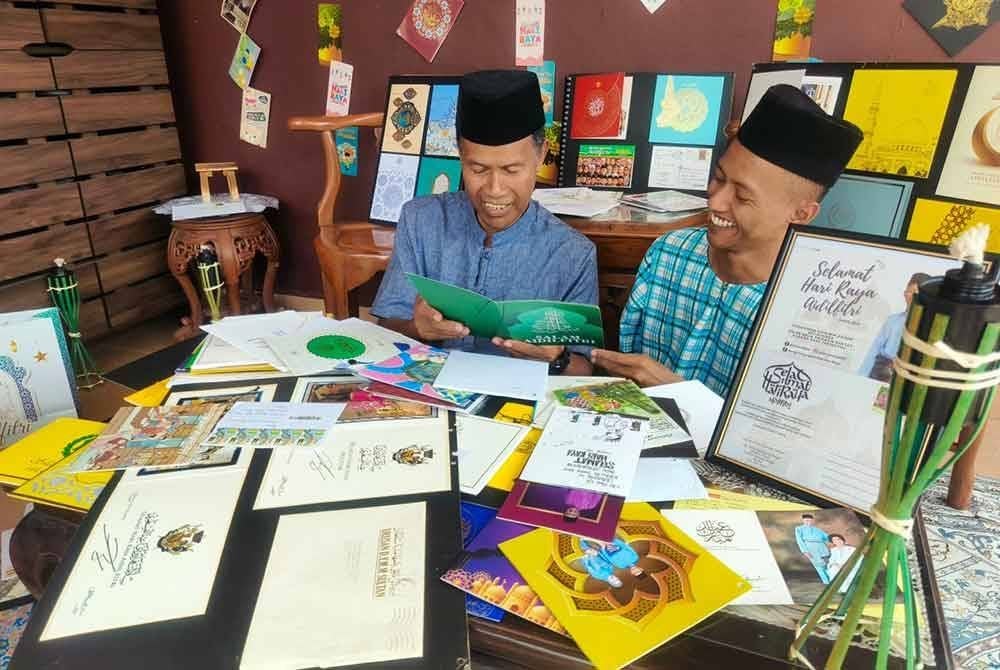 Muhammad Azim (kanan) mengikut jejak langkah bapanya mengumpul kad hari raya.