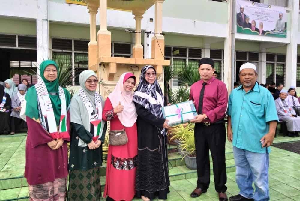 Nik Emran (dua, kanan) menerima sumbangan al-Quran daripada pengurusan Program World #QuranHour 2025.